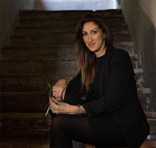 Person sitzt auf Treppe, lächelt.