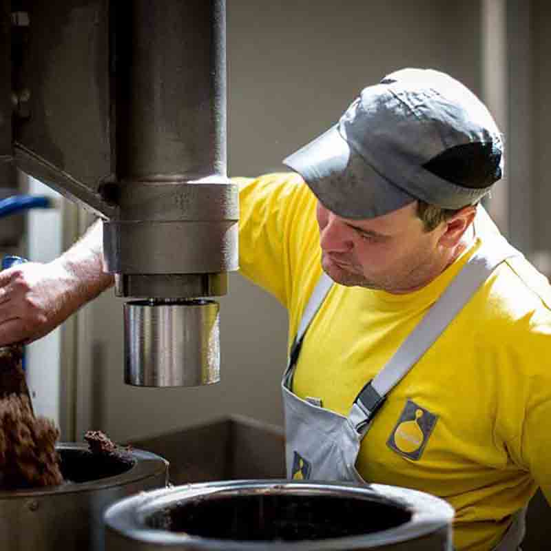 Ein Mitarbeiter schaltet die Pressanlage ein.