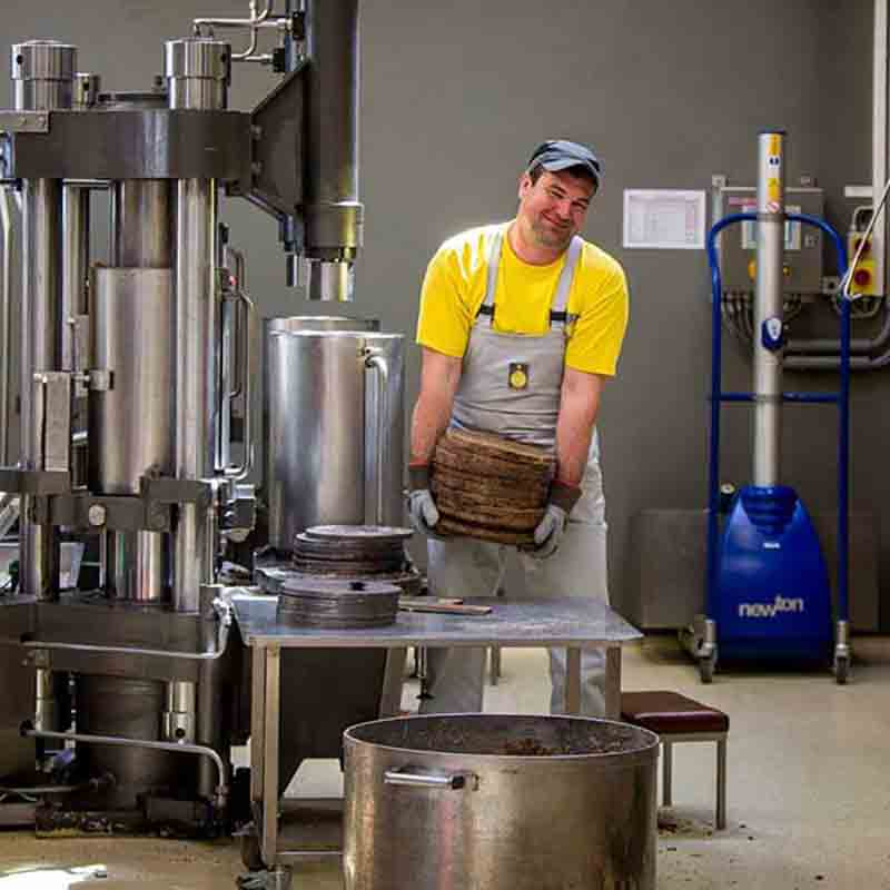 Ein Mitarbeiter von Fandler hält einen Presskuchen in der Hand.