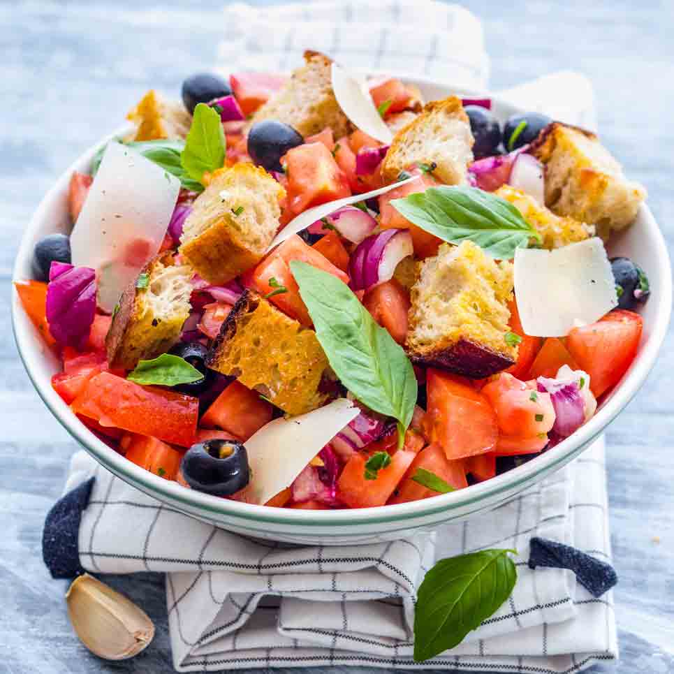 Tomaten-Brot-Salat mit Oliven, Basilikum und Parmesan.