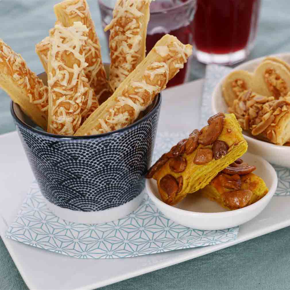 Käsegebäck in Schale, serviert auf Tisch mit Getränken.