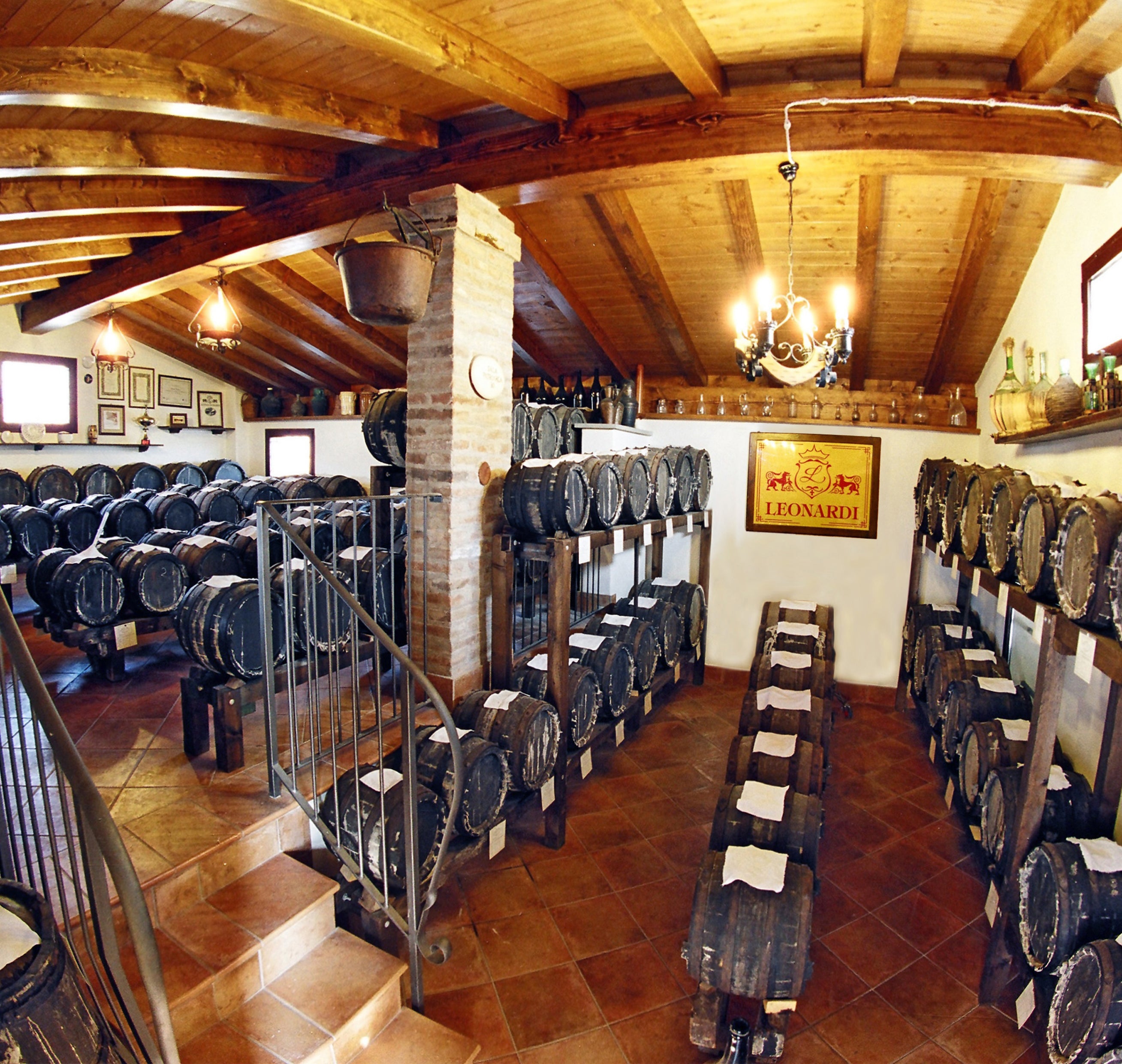 Weinkeller mit Holzfässern, Leonardi-Logo an der Wand.