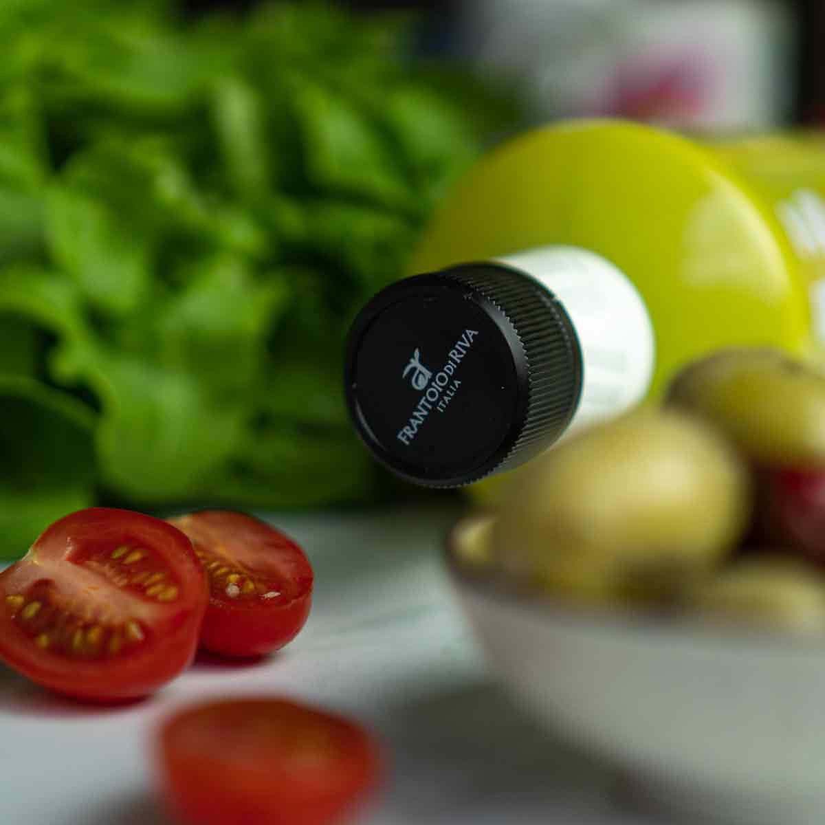 Flasche Olivenöl Agraria Riva Garda, Tomaten, Salat, Kartoffeln.