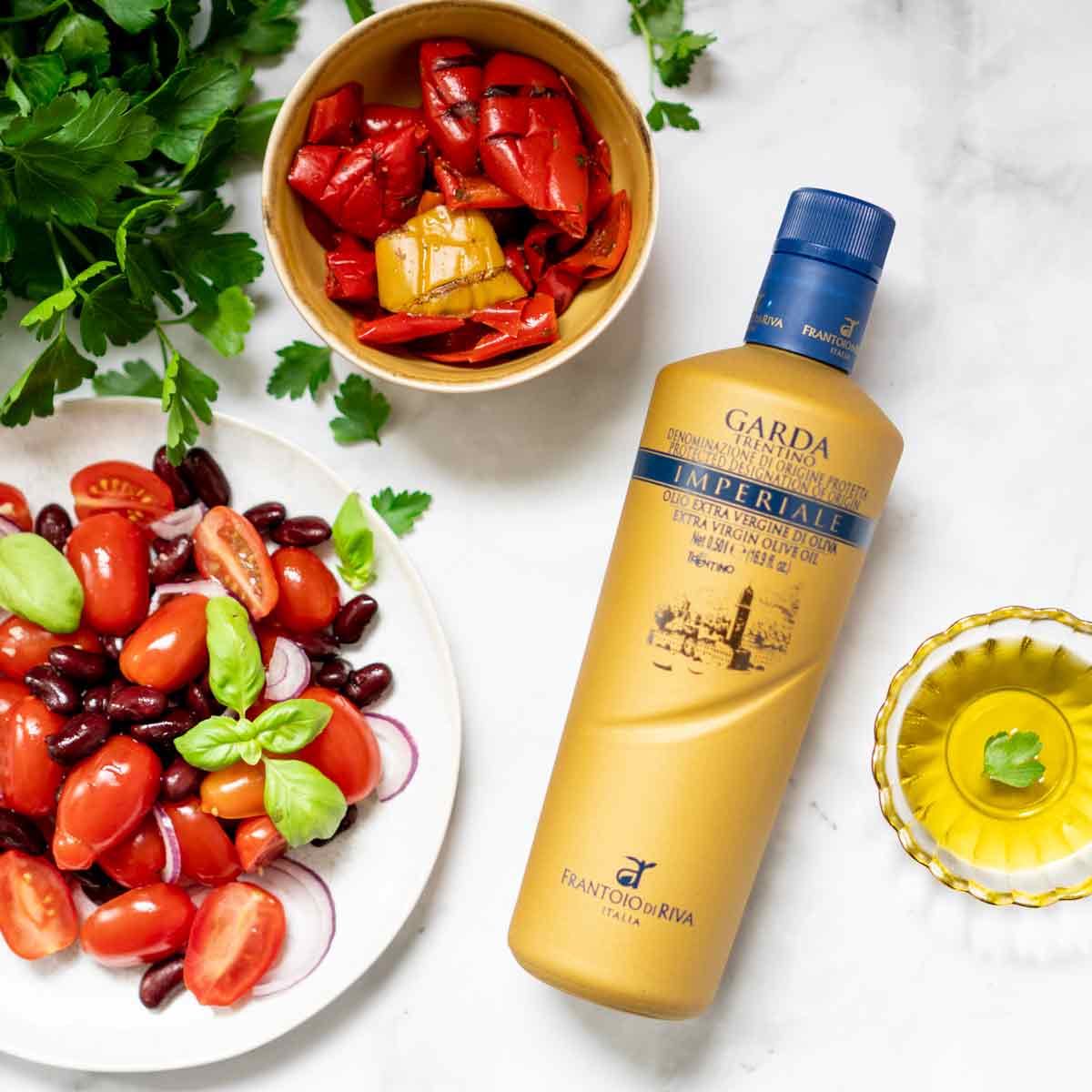 Olivenölflasche Garda Imperiale mit frischen Tomaten und Paprika.