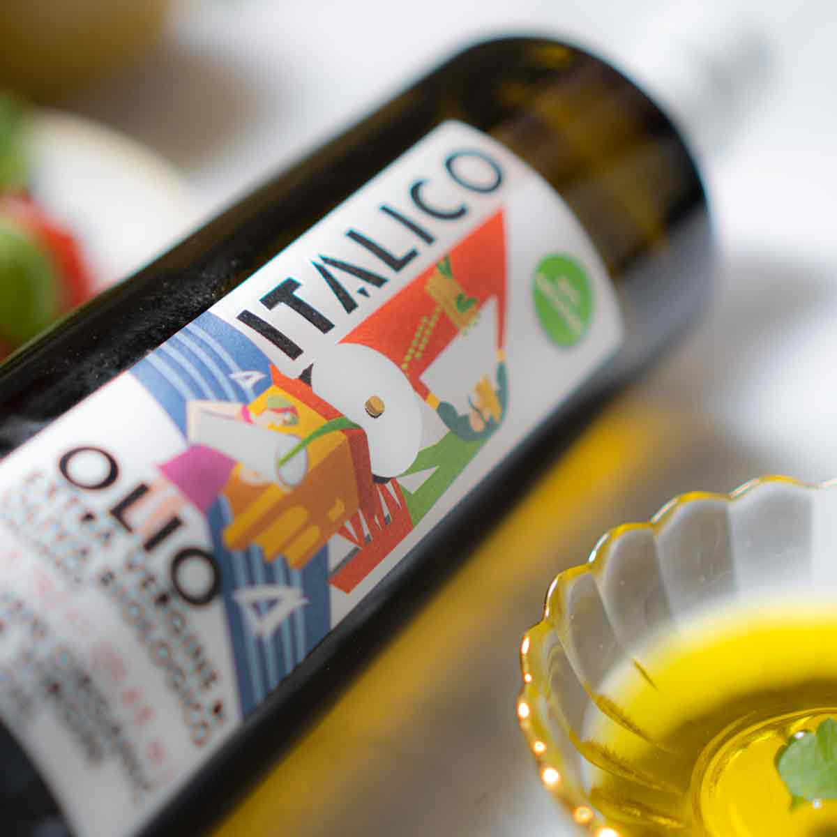 Olivenölflasche Italico neben Schale mit Olivenöl.