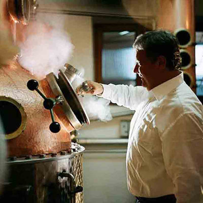 Mann bei Brennkessel mit Dampf.