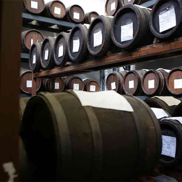 Holzfässer mit Balsamico-Essig in einem Lagerraum.