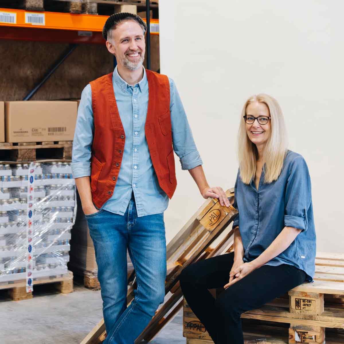 Zwei Personen vor Paletten.