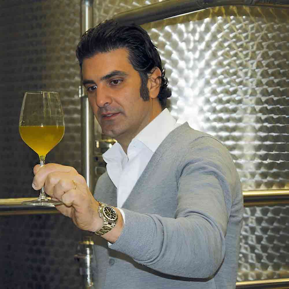 Mann betrachtet Glas mit Flüssigkeit.