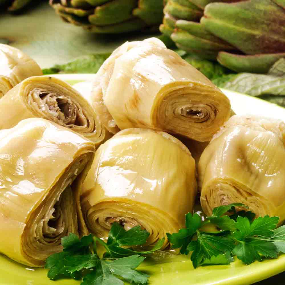 Artischockenherzen auf Teller mit Petersilie, Nahaufnahme.