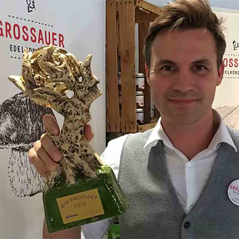 Mann mit Auszeichnung in Hand.