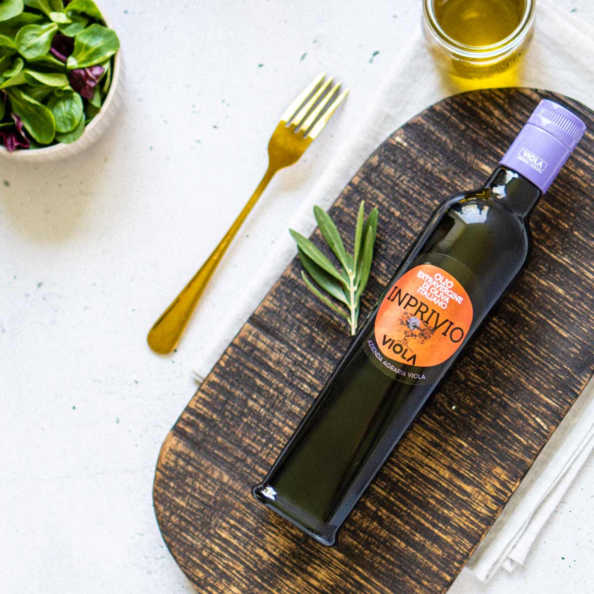 Olivenölflasche "Imprivio" von Viola auf Holzbrett.
