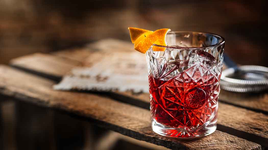 Cocktail mit Orangenschale auf Holztisch, Balsamico-Cocktail.