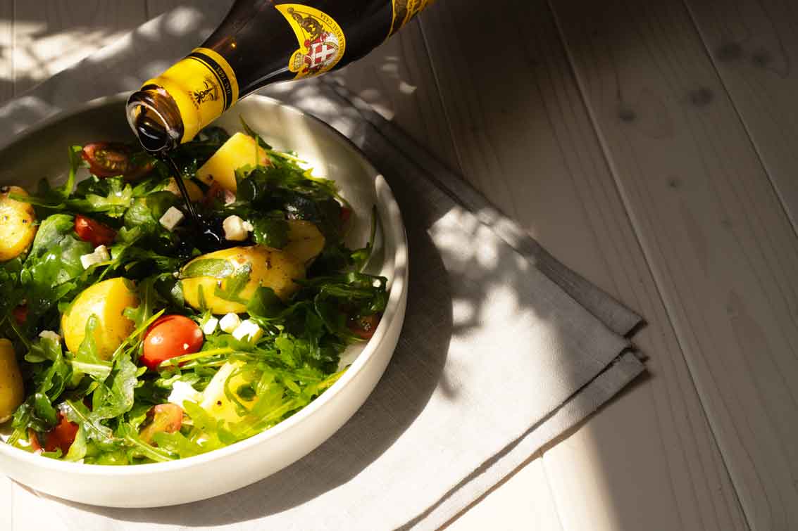 Salat mit Balsamico-Dressing, Rucola, Tomaten und Kartoffeln.