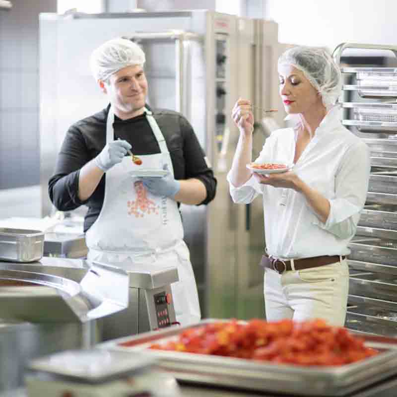Bettina Fink-Haberl in der Küche beim Verkosten delikater Speisen.
