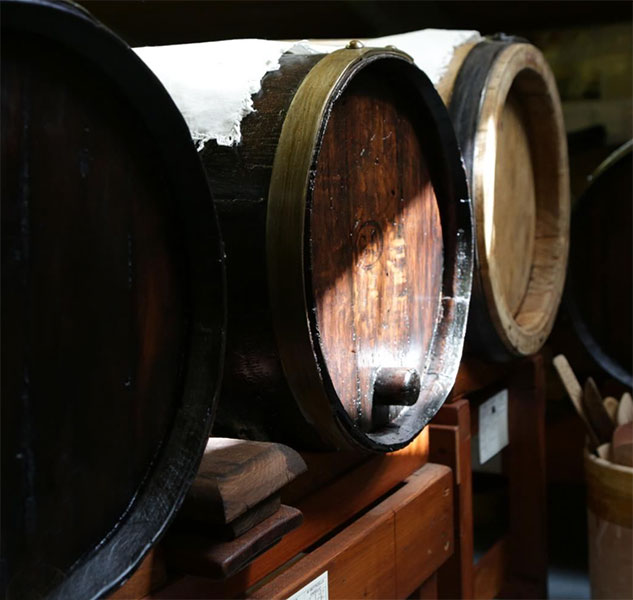 Holzfässer für Essig in einem Lagerraum.