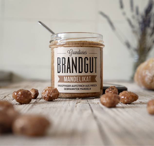 Glas Brandgut Mandelikat mit Mandeln auf Holztisch.