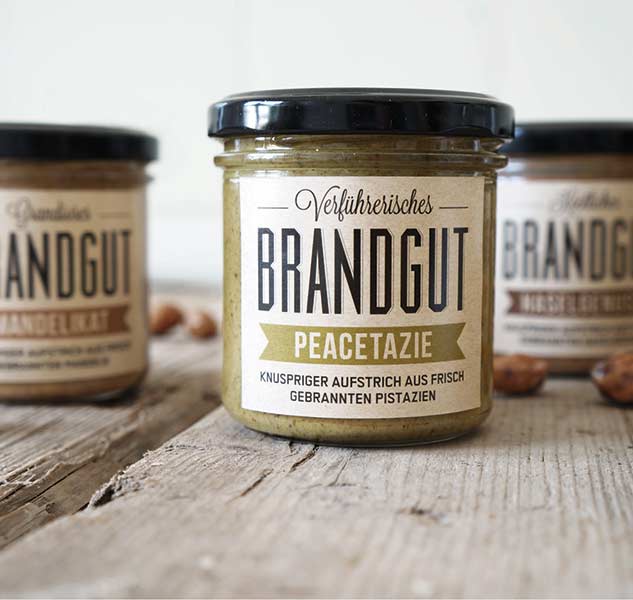 Drei Gläser Brandgut Aufstrich auf Holztisch.