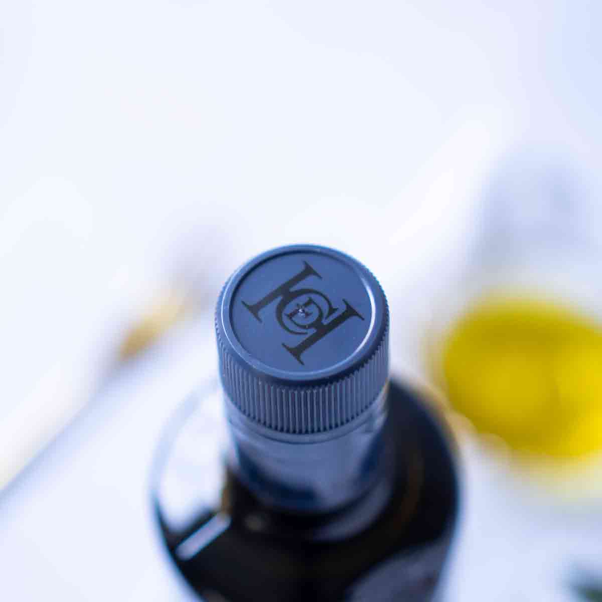 Olivenölflasche mit Casas de Hualdo Logo auf Deckel.