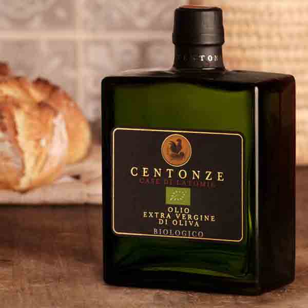 Centonze Bio Olivenöl Flasche neben Brotlaib auf Tisch.