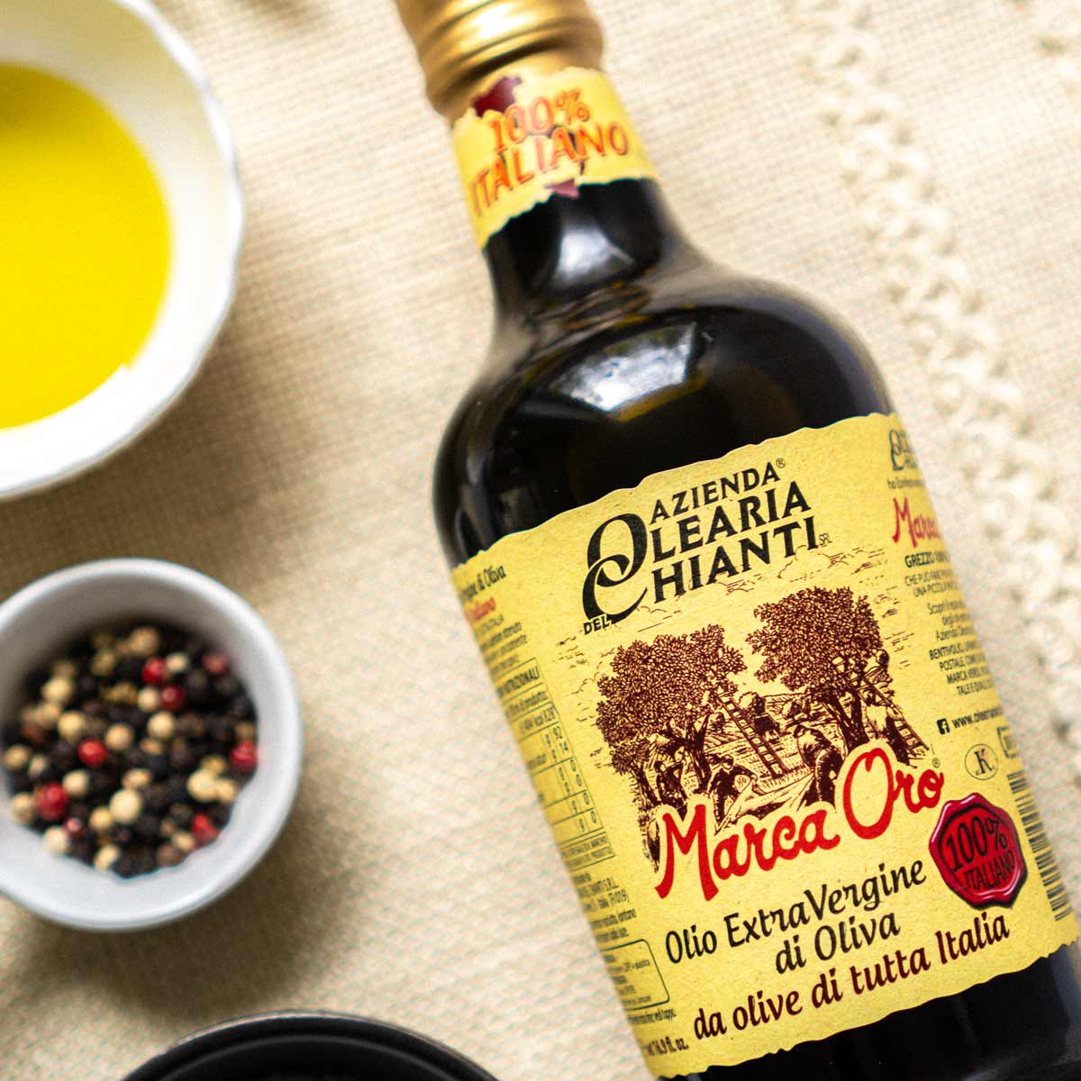 Flasche Olearia Chianti Olivenöl mit Schalen und Gewürzen.