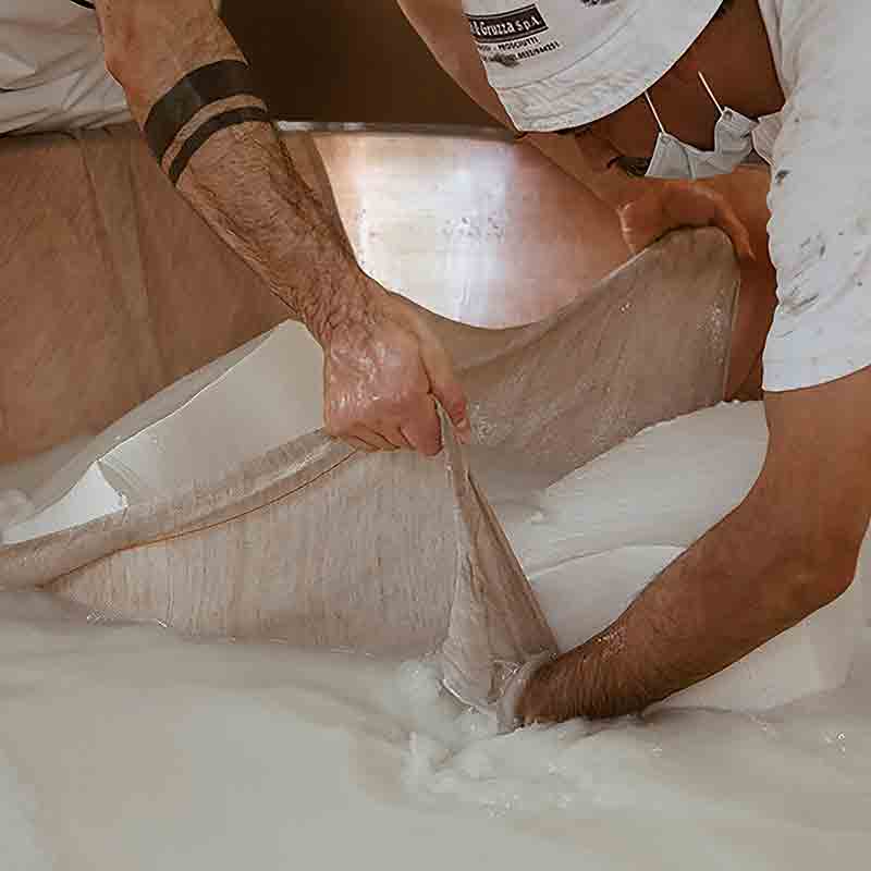 Käseherstellung in großer Wanne.