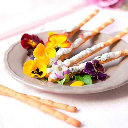 Grissini mit essbaren Blüten dekoriert.