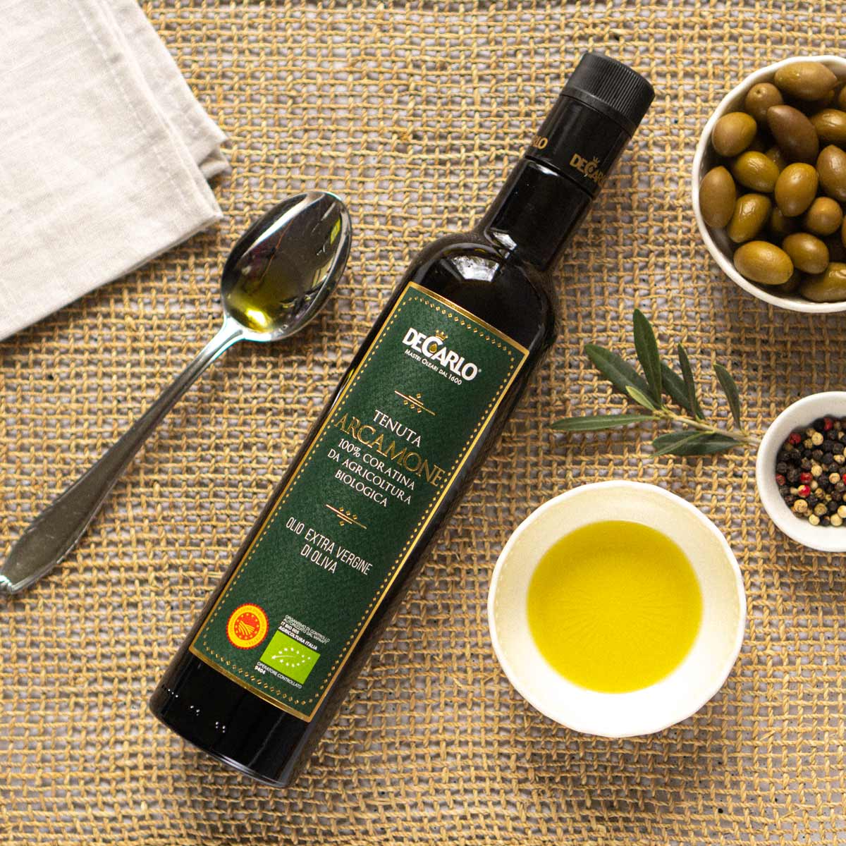 Olivenölflasche, Schale, Löffel, Oliven, Pfeffer, De Carlo.