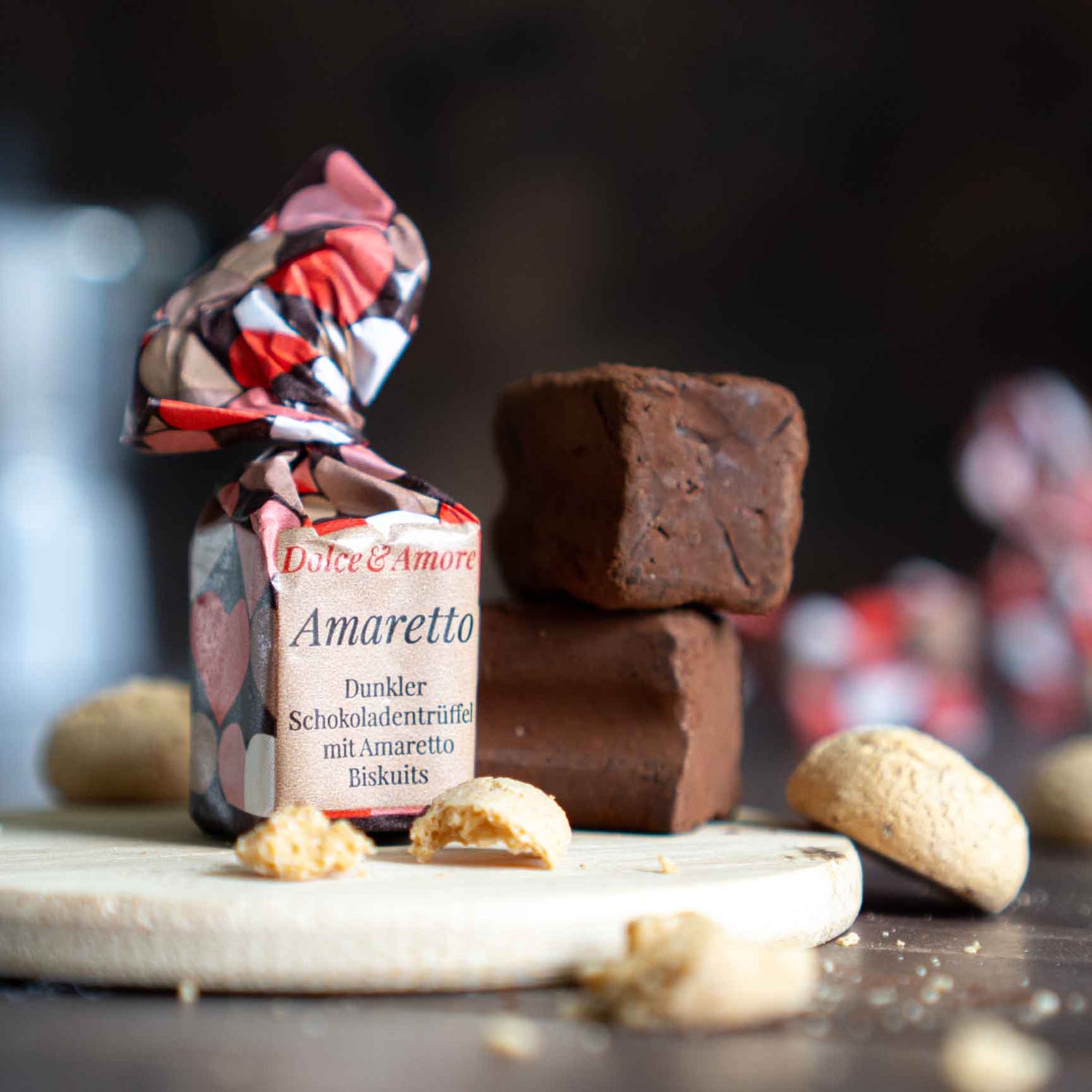 Dolce Amore Trüffelpralinen (Dunkler Schokotrüffel mit Amaretti Biskuits) liegen stimmungsvoll auf einem Tisch