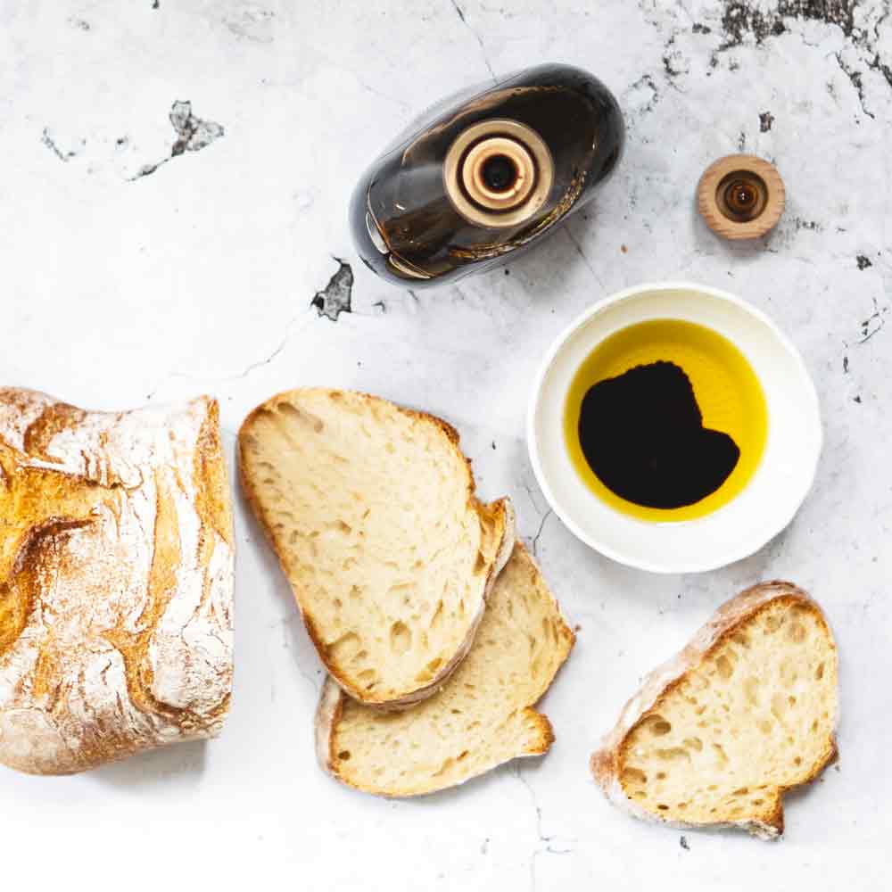Brot, Olivenöl, Essig, Due Vittorie Flasche auf Marmortisch.