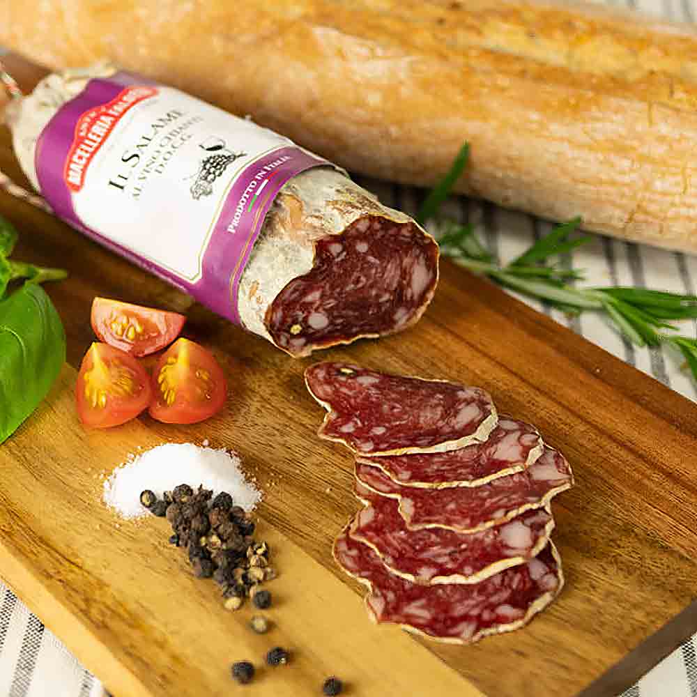 Salami, Baguette, Tomaten, Pfeffer, Salz auf Holzbrett.