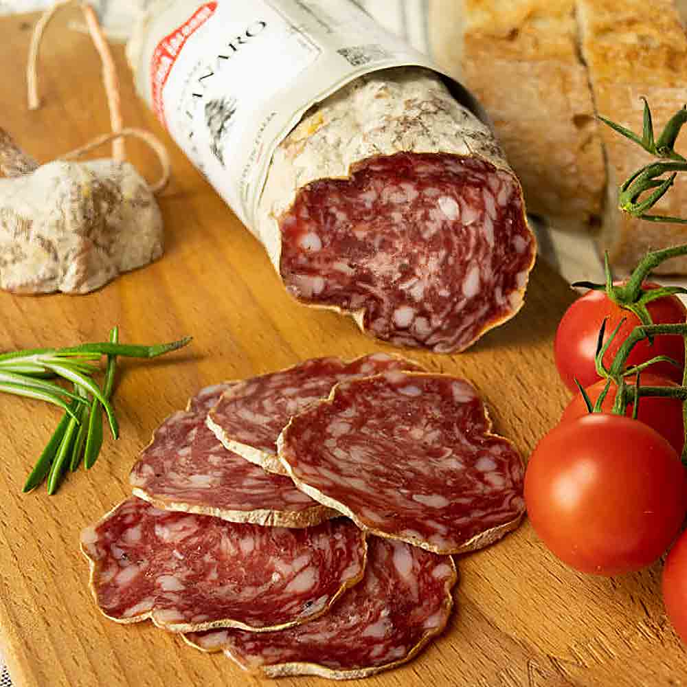 Salami, Tomaten, Brot und Rosmarin auf Holzbrett.