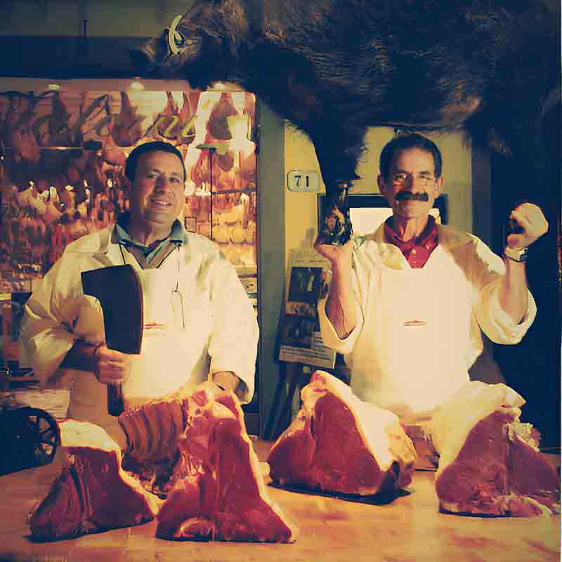 Zwei Metzger mit Fleischstücken.