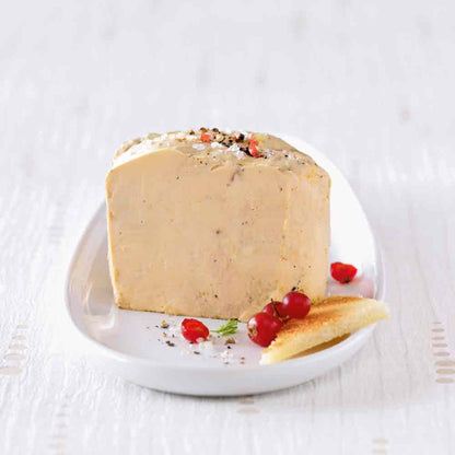 Foie gras auf Teller mit Johannisbeeren und Brot.