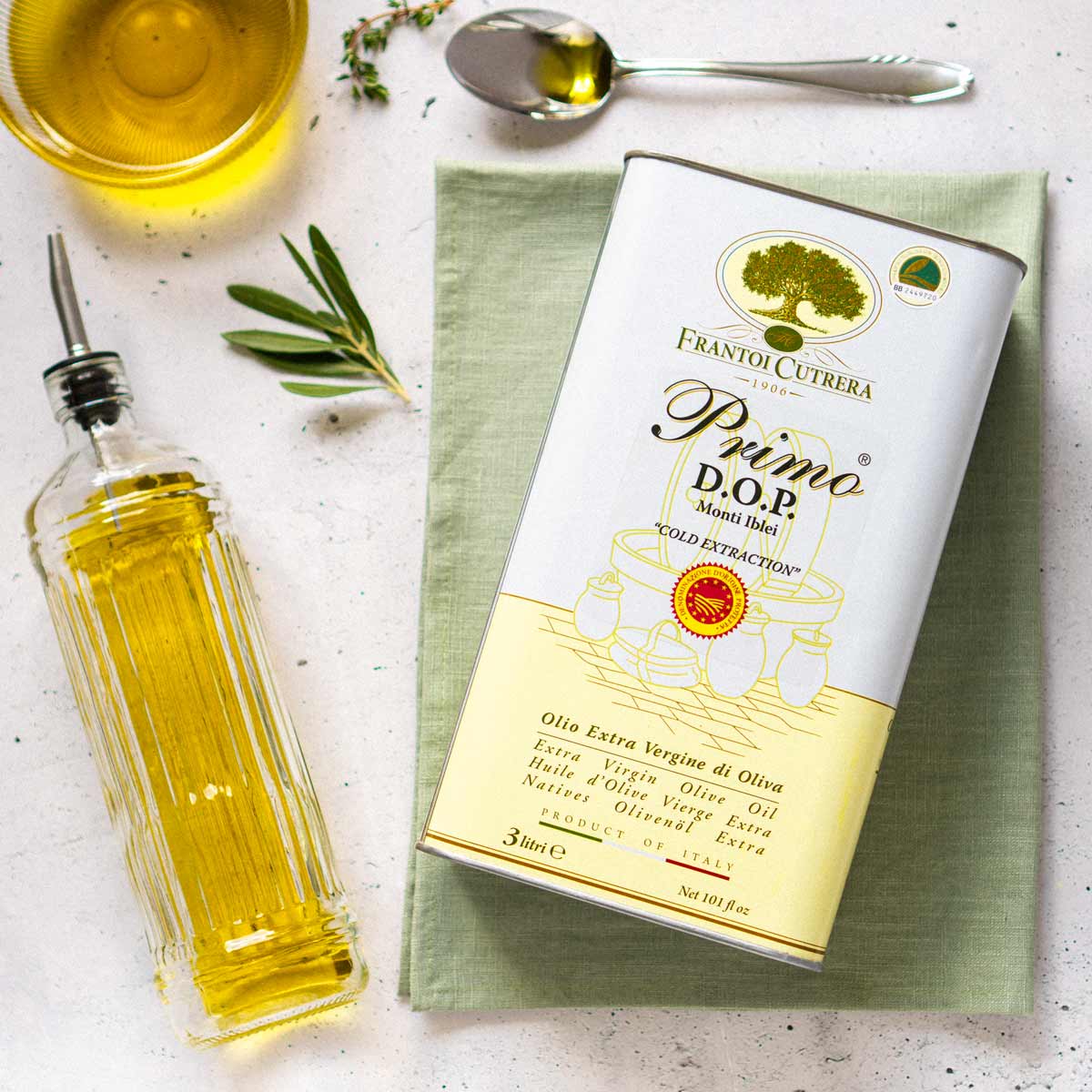 Frantoi Cutrera Olivenöl, Flasche, Löffel, Olivenzweig, Tuch.
