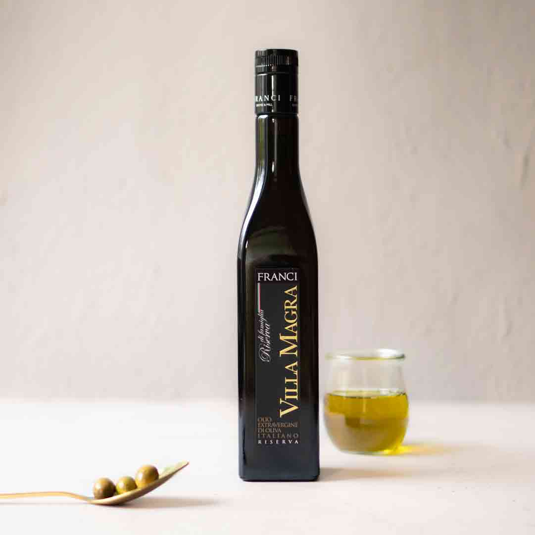 Flasche Frantoio Franci Olivenöl, Glas, Löffel mit Oliven.