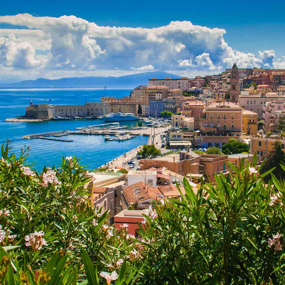 Küstenstadt mit Hafen und Blumen.