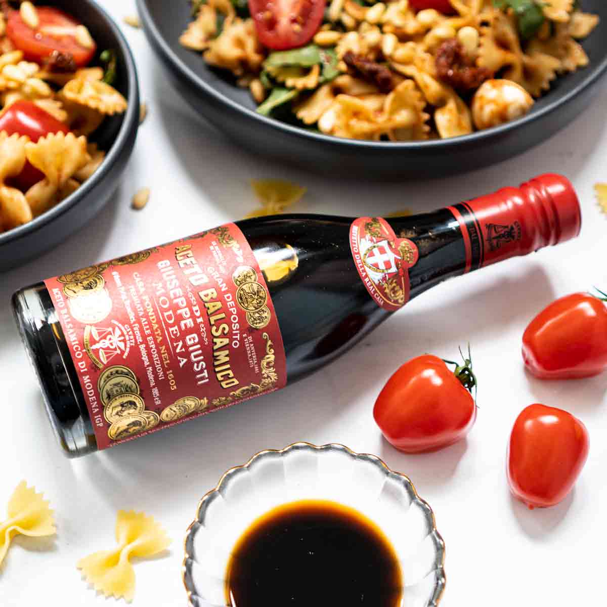 Balsamico-Essigflasche Giusti mit Tomaten und Pasta.