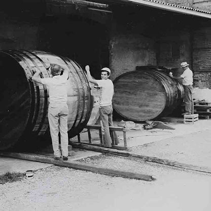 Männer arbeiten an großen Fässern.
