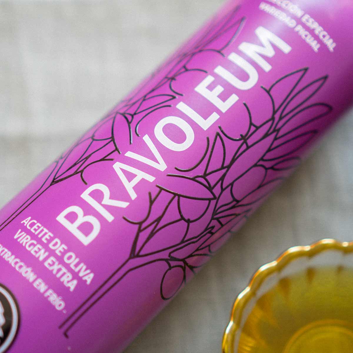 Bravoleum Olivenölflasche mit Schale Olivenöl daneben.