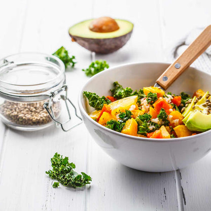 Salat mit Hanfsamen, Avocado und Grünkohl auf Holztisch.