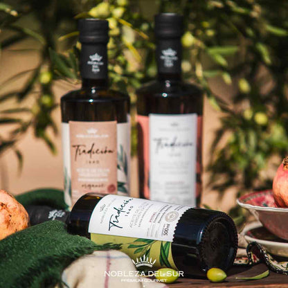 Olivenölflaschen von Nobleza del Sur mit Olivenhintergrund.