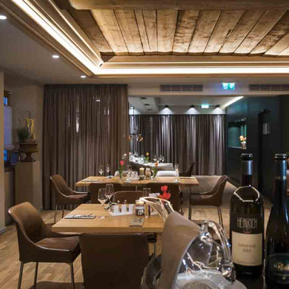 Feinkostladen mit Weinflaschen, Olivenöl und Geschenken auf Tischen.