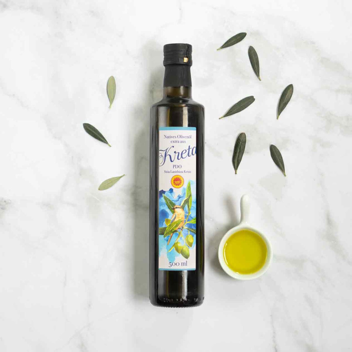 Flasche Kreta Olivenöl mit Olivenblättern und Schale.