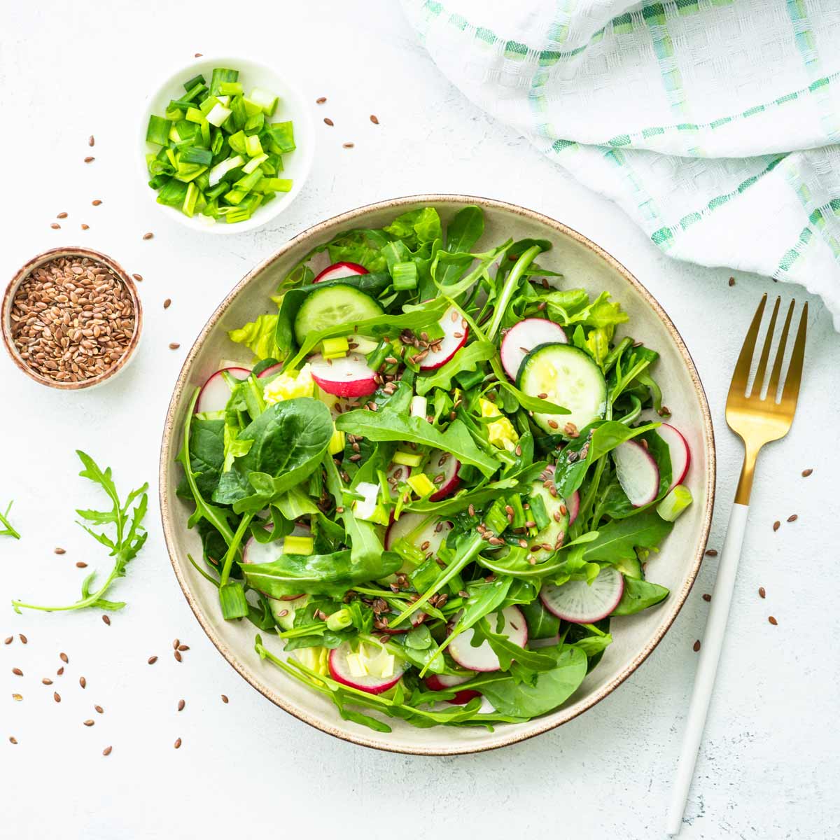 Salat mit Leinsamen, Radieschen, Gurken und Frühlingszwiebeln.