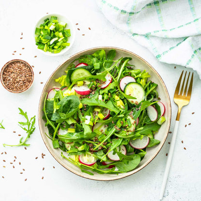 Salat mit Leinsamen, Radieschen, Gurken und Frühlingszwiebeln.