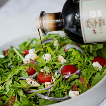 Balsamico-Essig von Leonardi wird über Salat gegossen.