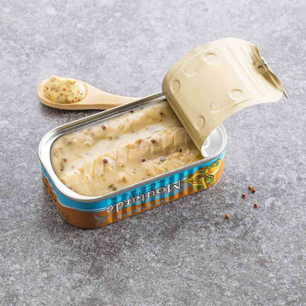 Makrelenfilet in Senfsauce, geöffnete Dose auf grauem Hintergrund.