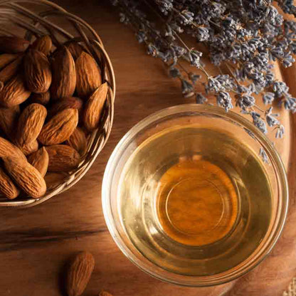 Mandeln, Mandelöl und Lavendel auf Holzuntergrund arrangiert.