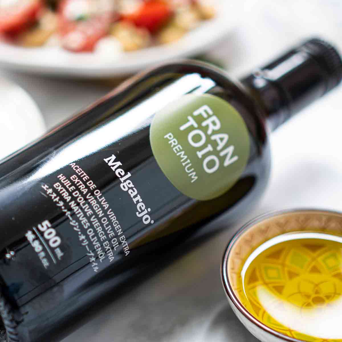 Flasche Melgarejo Frantoio Olivenöl neben Schale mit Öl.